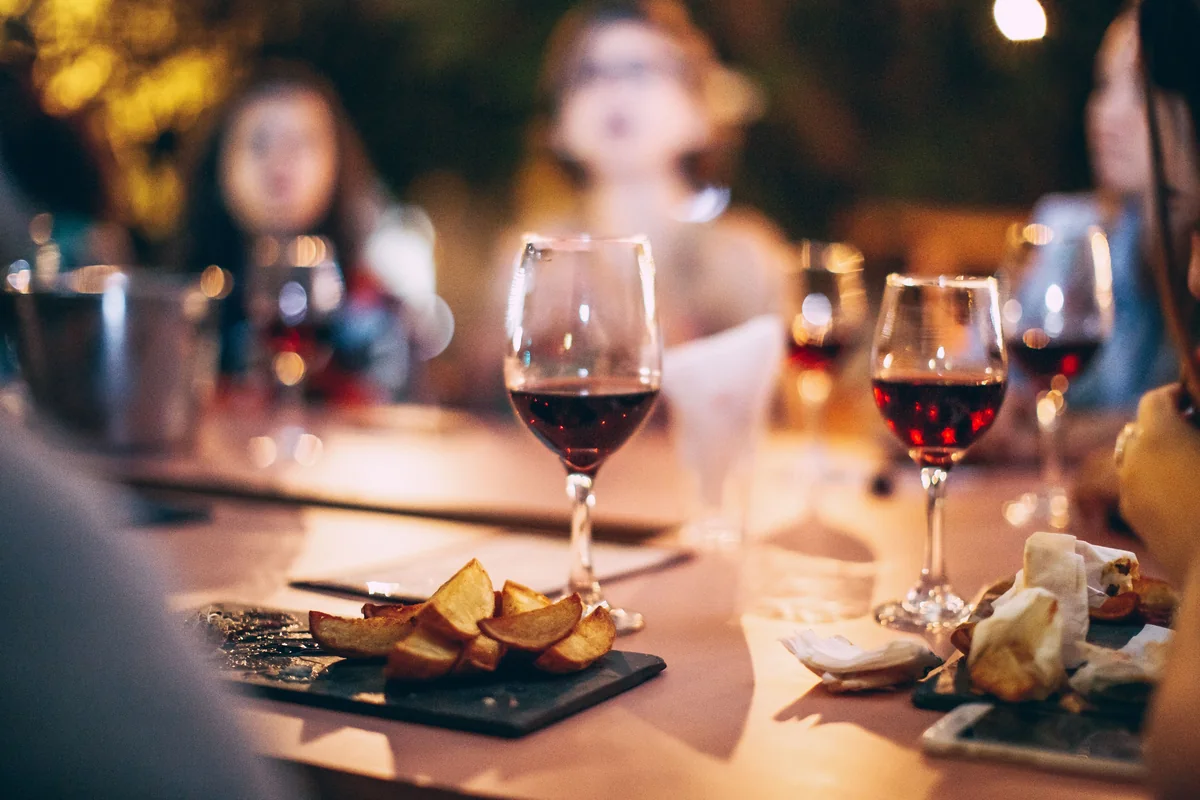 A glass of red wine on a set dinner table
